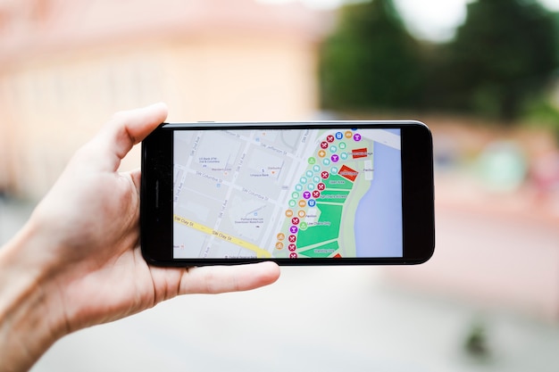 Tourist holding smartphone with map gps navigation on screen