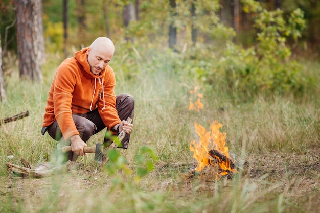 Tourist kindles a fire in summer wood