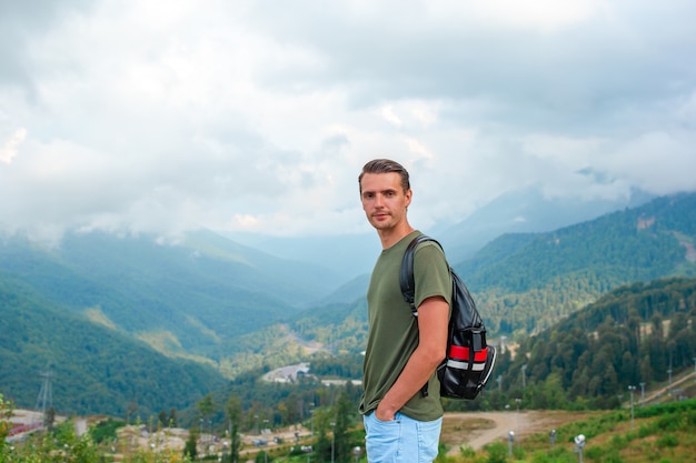 Tourist man in mountains in the background of fog