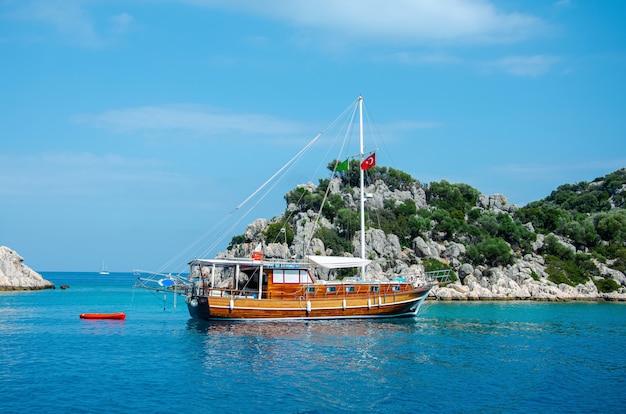 Tourist ship on the background of a beautiful summer mountain landscape on the Mediterranean sea. 