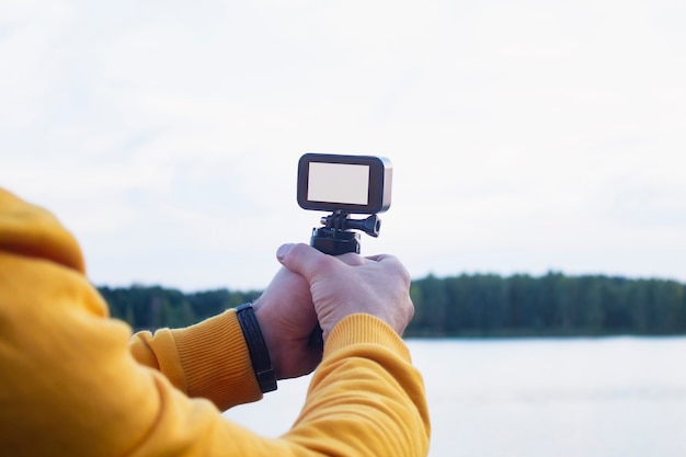 Tourist shoots a video on an action camera in nature