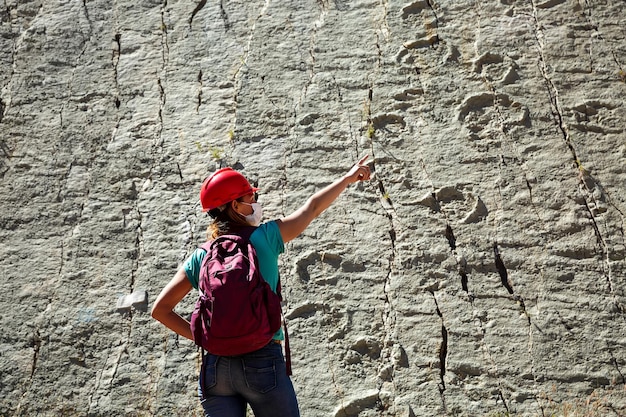 A tourist  shows on the fossil footprints of ancient reptiles on a rock in the dinosaur parkSucre