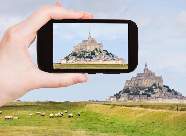 Tourist taking photo of mont saintmichel abbey