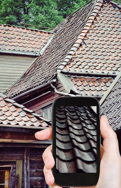 Tourist taking photo roof of wooden houses in rain