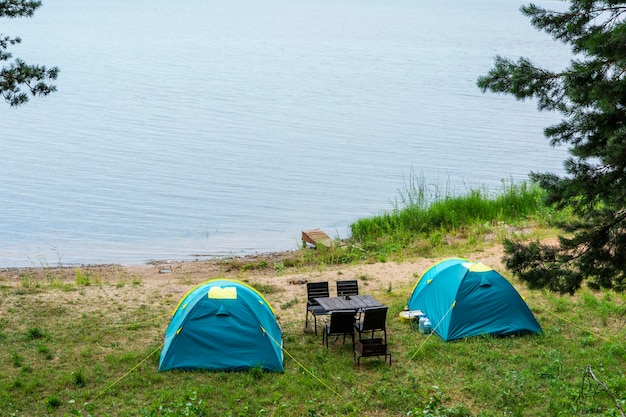 Tourist tents for camping on the lake shore travel history fishing tourism active recreation