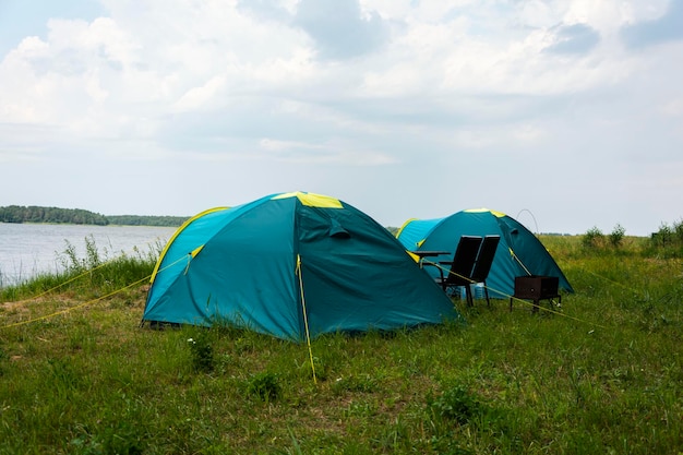 Tourist tents for camping on the lake shore travel history fishing tourism active recreation