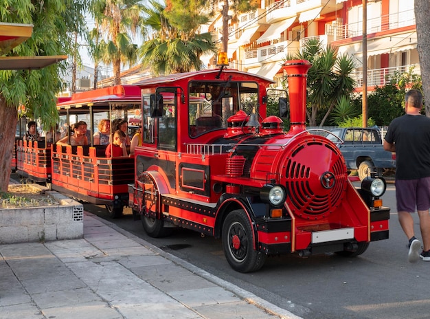 Tourist train-attraction with tourists on the street of the Greek resort in Greece