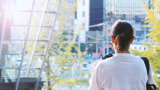 Behind tourist or traveller standing taking a photo of tower in Osaka Japan near station around