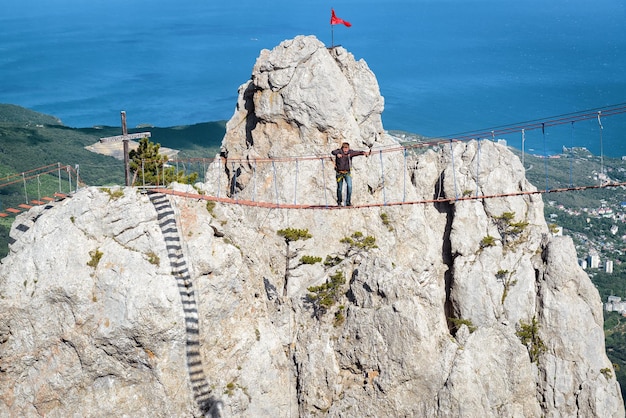 Tourist walking on rope bridge on the Mount AiPetri Crimea