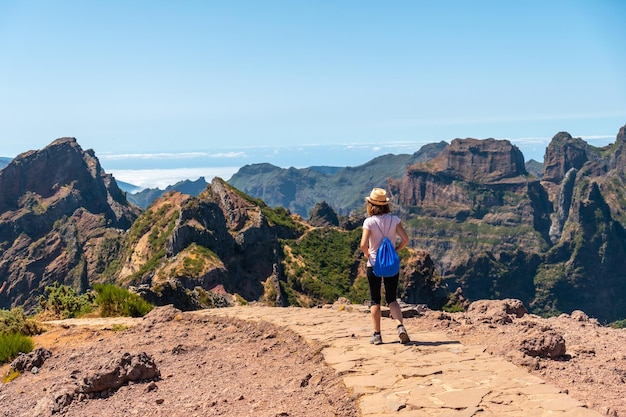 A tourist walking on the trekking trail at Pico do Arieiro Madeira Portugal