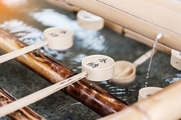 Tourist washing hands in pavilion at Fushimi Inari Shrine located in Fushimiku landmark and popular for tourists attractions in Kyoto Japanese text is mean good luck