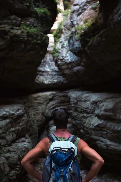 Tourist with a backpack in a high gorge in the mountains of Dagestan Saltinsky canyon waterfall Active recreationhiking