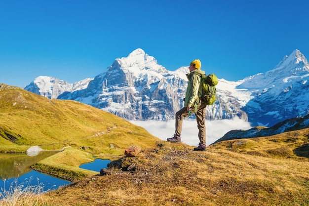 Tourist with a backpack in the mountains Mountain hiking in the high mountains Travel and adventure Active life Landscape in the summertime Photo with high resolution