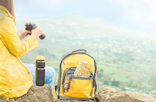 Tourist with binoculars looking at scenic view in mountains