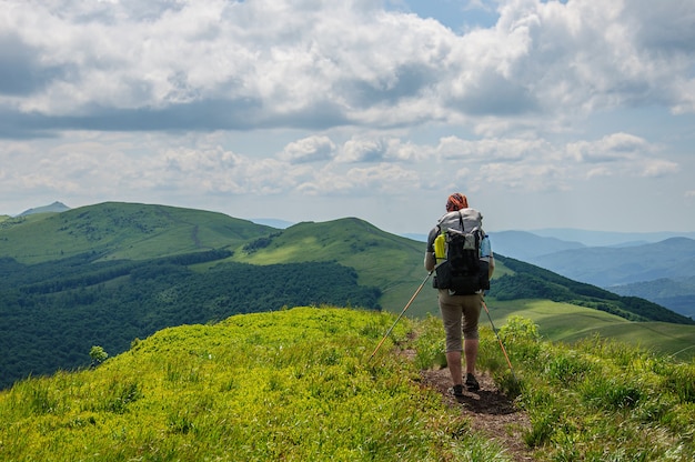 A tourist with a large backpack walks along the Carpathian mountain range in Ukraine