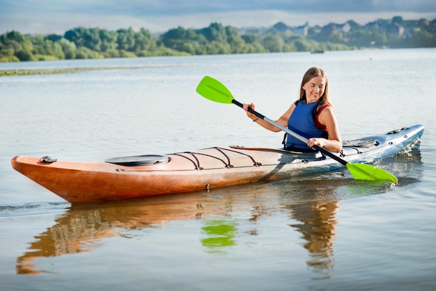 Tourist woman paddling kayak alone on lake A girl goes on a water excursion on vacation