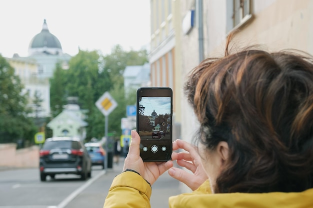 Tourist woman photographs a landmark while walking around the city