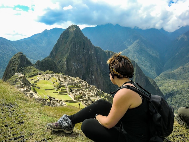 Tourist woman posing in the citadel of Machu Picchu Huayna Picchu mountain in Cusco Peru