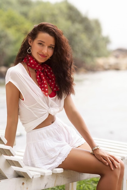 Tourist woman in summer stylish outfit on a beach chair during vacations