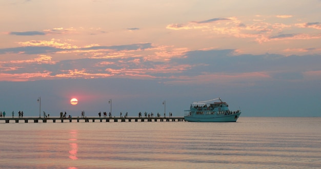 Touristic ship leaving the pier at sunset