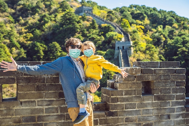 Tourists dad and son in medical mask at great wall of china chinese destination travel with children