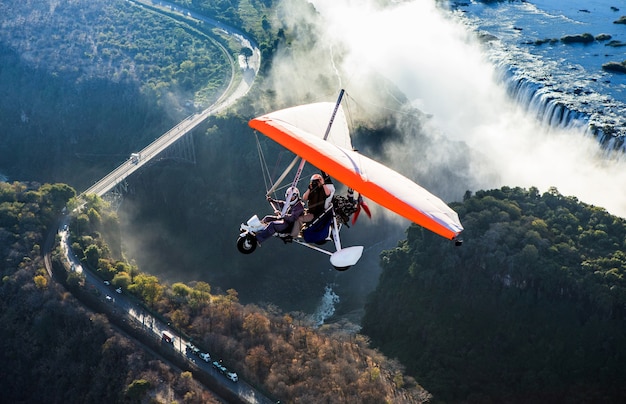 Tourists fly over the Victoria Falls on the trikes. Africa. Zambia. Victoria Falls.