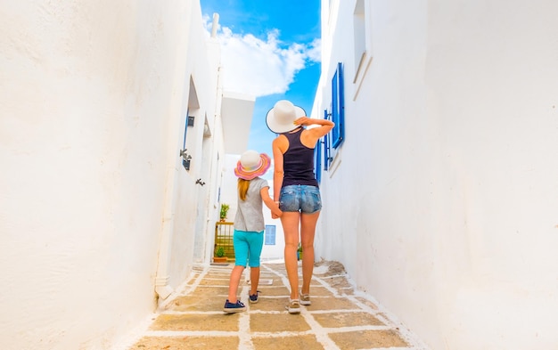 Tourists mother and daughter seeing sights on a typical greek street on a holiday