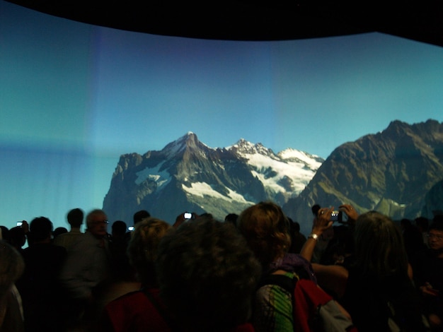 Photo tourists on mountain against cloudy sky