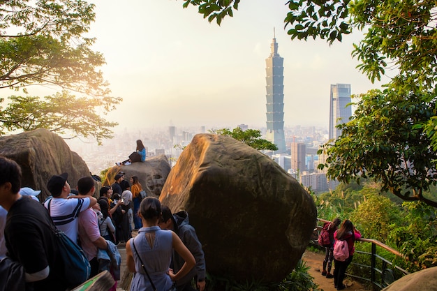 Tourists take pictures with 101 tower at sunset 