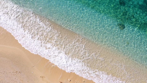 Tourists walking on sandy beach of tropical island top view from drone vacation concept