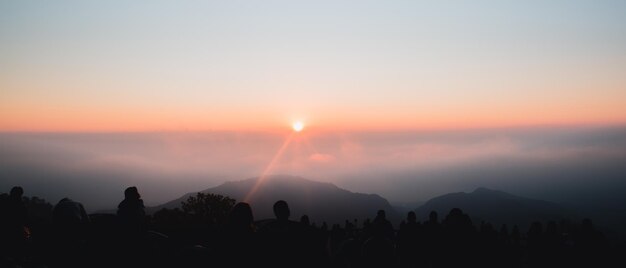 Tourists watching the beautiful sunset in the evening on the mountain