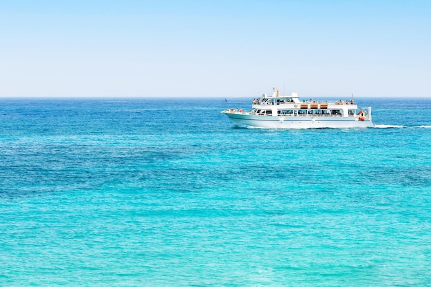 Tourists white boat trip in idyllic lagoon near coast of Cyprus Summer adventure active vacation in Mediterranean sea