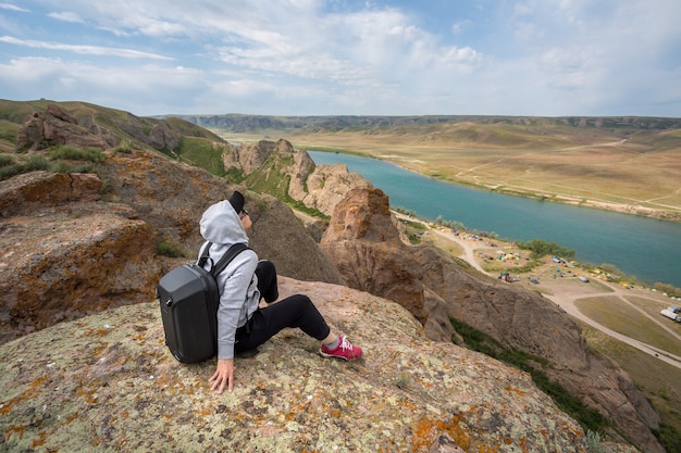 Photo tourists with backpacks relaxing on rocks