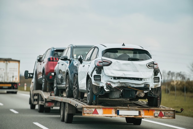 Tow truck with broken car on country road Tow truck transporting car on the highway Car service transportation concept