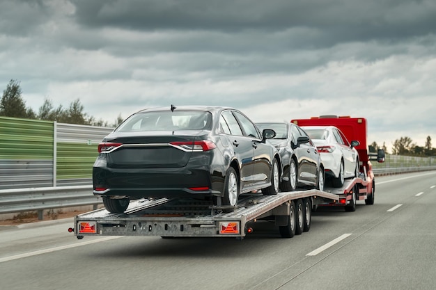 Tow truck with a cars on the highway road Tow truck transporting car on the autobahn Car service transportation concept Roadside Rescue