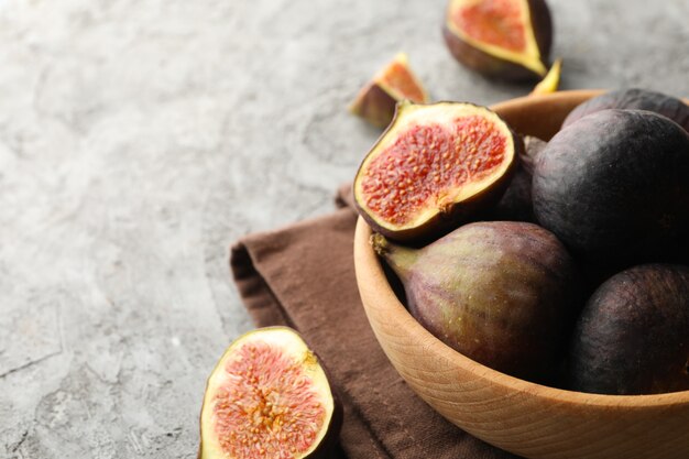 Towel and bowl with fig on gray, copy space