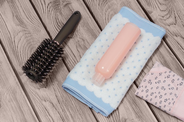 Towel shampoo and women accessories on a wooden background