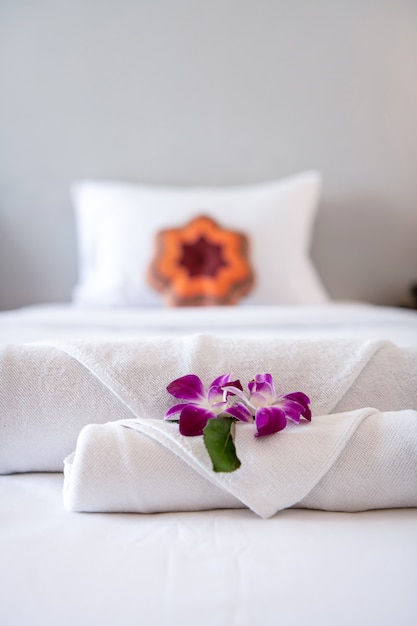 Towel with Orchid on bed decoration in bedroom interior for hotel customer.