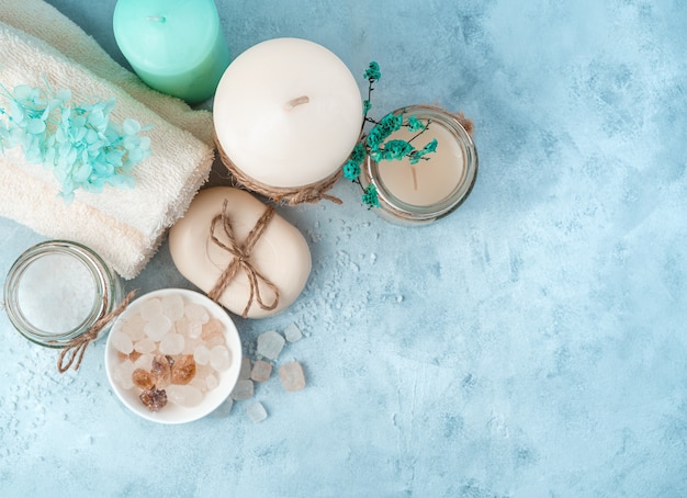 Towels, candles and cleaning products on a cyanide background. Top view, with space to copy. The concept of a healthy lifestyle.