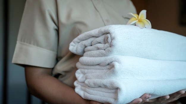 Towels in Hands of hotel maid for the luxury hotel room ready for tourist travel.