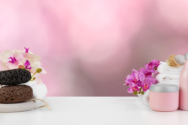 Towels with flowers on light table against blurred background