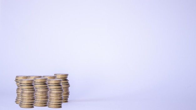 Tower of coins on top of table on white background