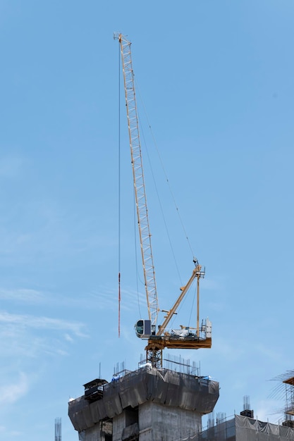 Tower construction crane in rooftop building construction site