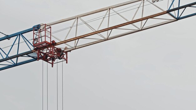 A tower crane against a white sky background