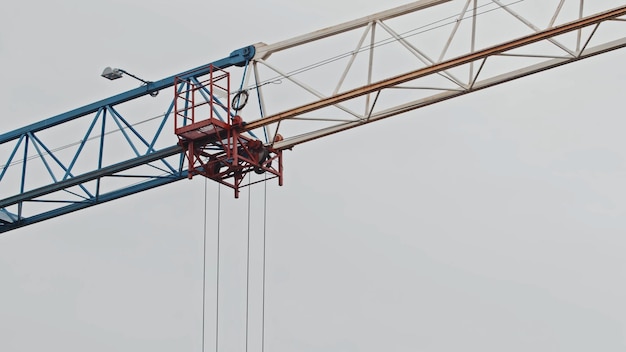 A tower crane against a white sky background