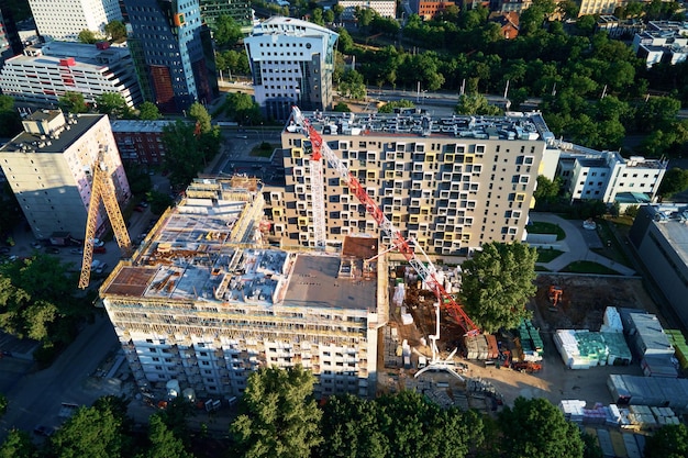 Tower crane on construction site with residential building under costruction