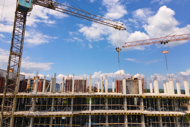 Tower crane at high concrete residential building under construction Real estate development concept