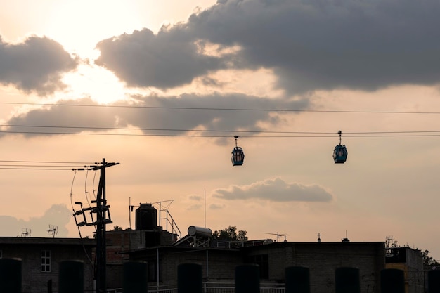 Tower with two teleferico or cablebus cabins in Mexico City with the sky in the background