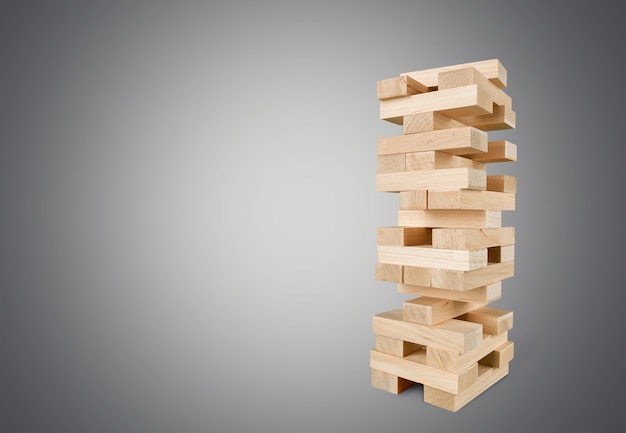 Tower of wooden cubes from table game over grey background