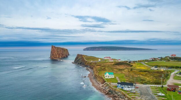 Town on the atlantic ocean coast during a cloudy sunset perce quebec canada